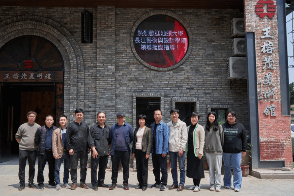 一群人站在砖墙前合照描述已自动生成