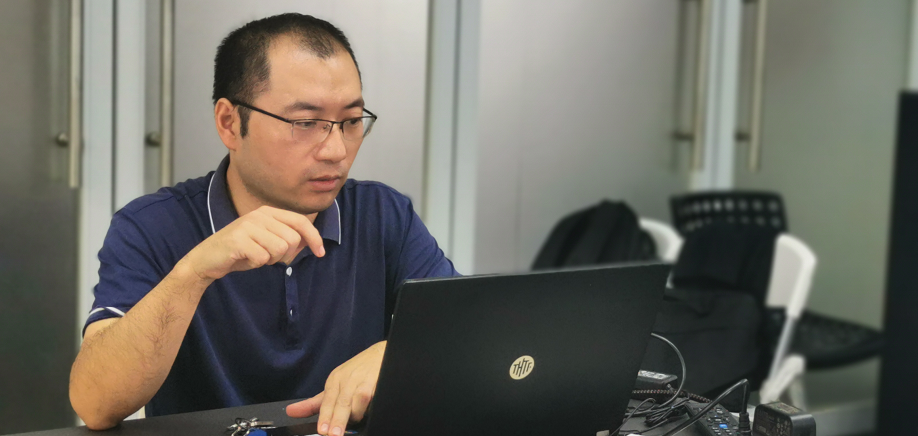 男人拿着笔记本电脑描述已自动生成